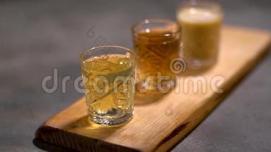 三个酒精芳香的酒，美味的服务停留在木桌上，准备饮用。 关门